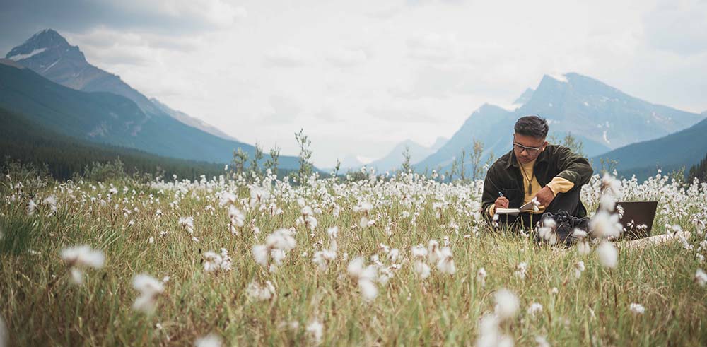 Marc Generoso writing in an open field